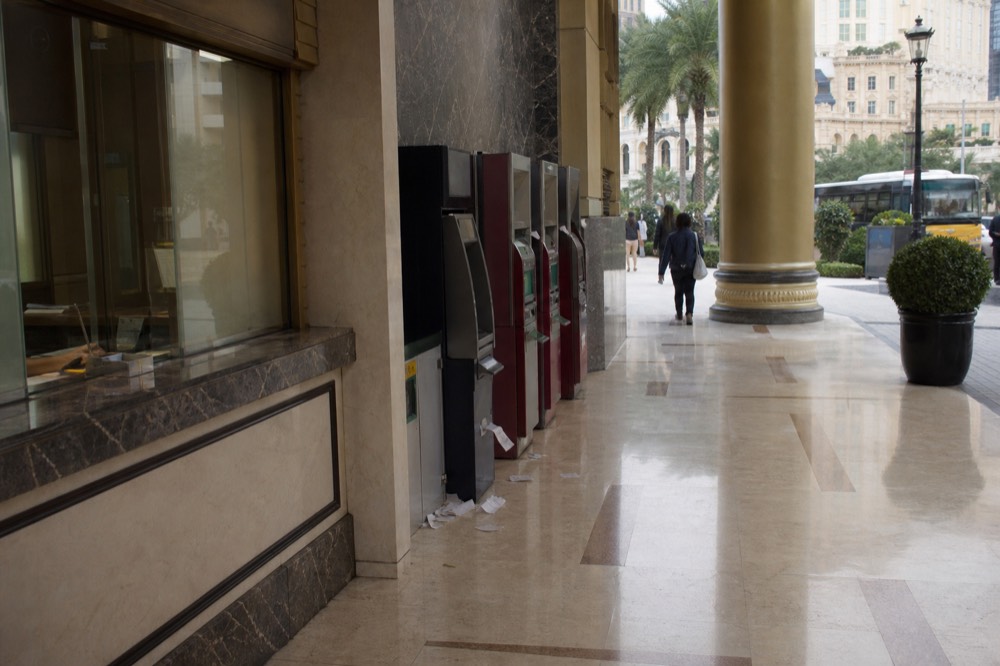 Currency exchange counter and ATM machines in a Macau resort walkway