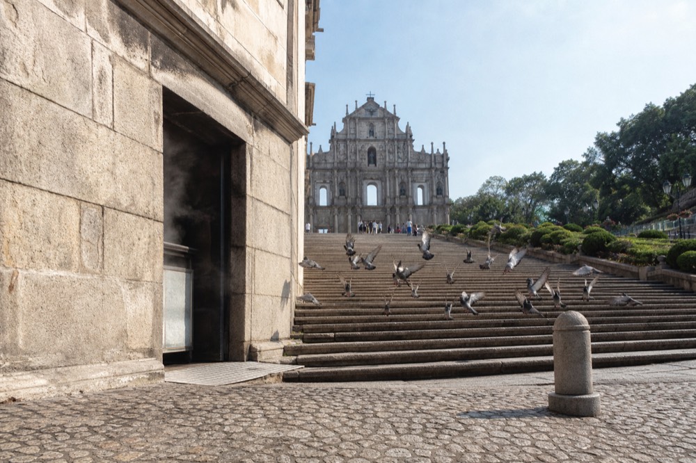Historic Macau street with pastel colonial facades and stone paving