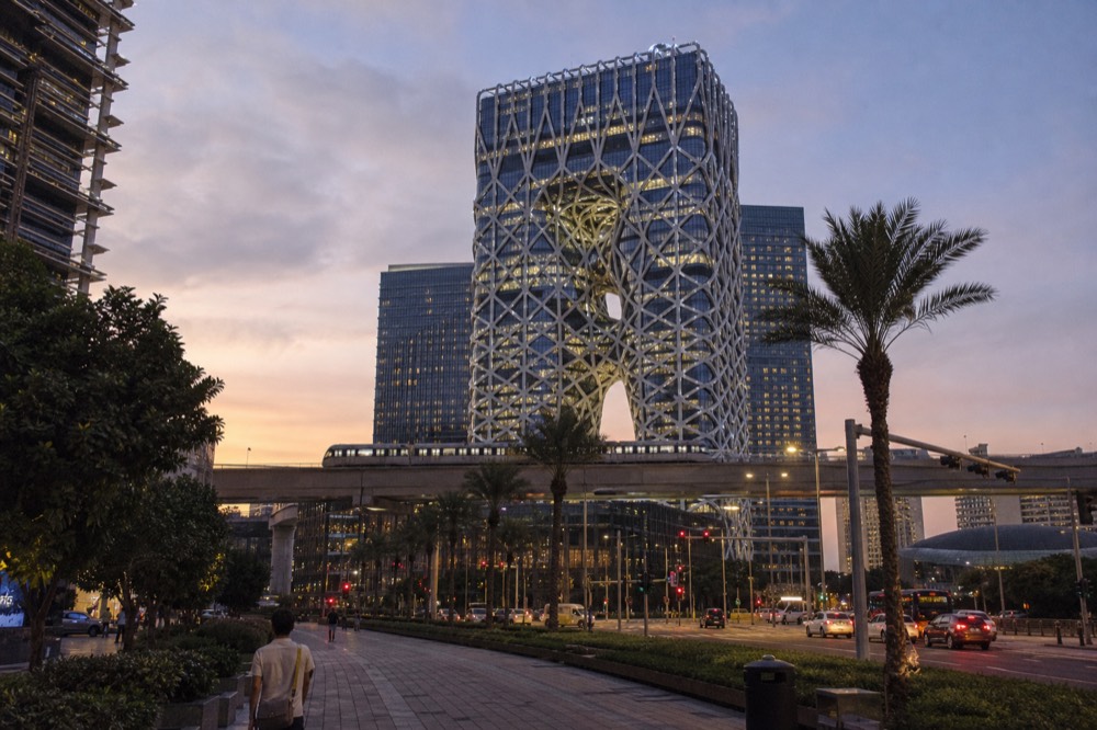 Hotel towers of the City of Dreams resort rising above Cotai at twilight