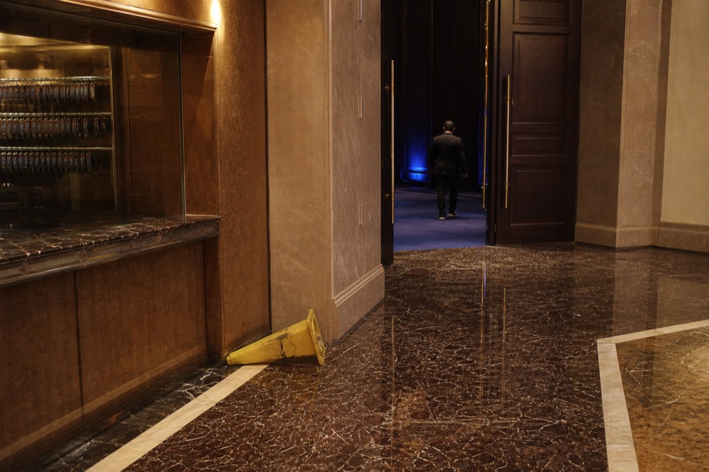 Theatre foyer corridor with cloakroom counter and posted entry notices beside auditorium doors