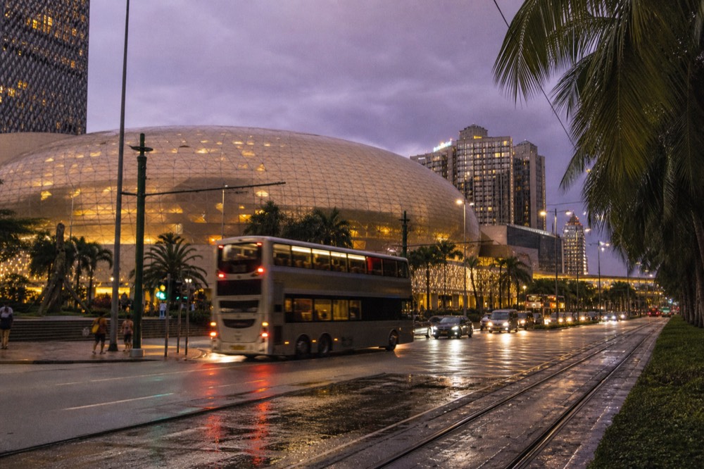 The illuminated exterior of the City of Dreams resort at dusk in Cotai