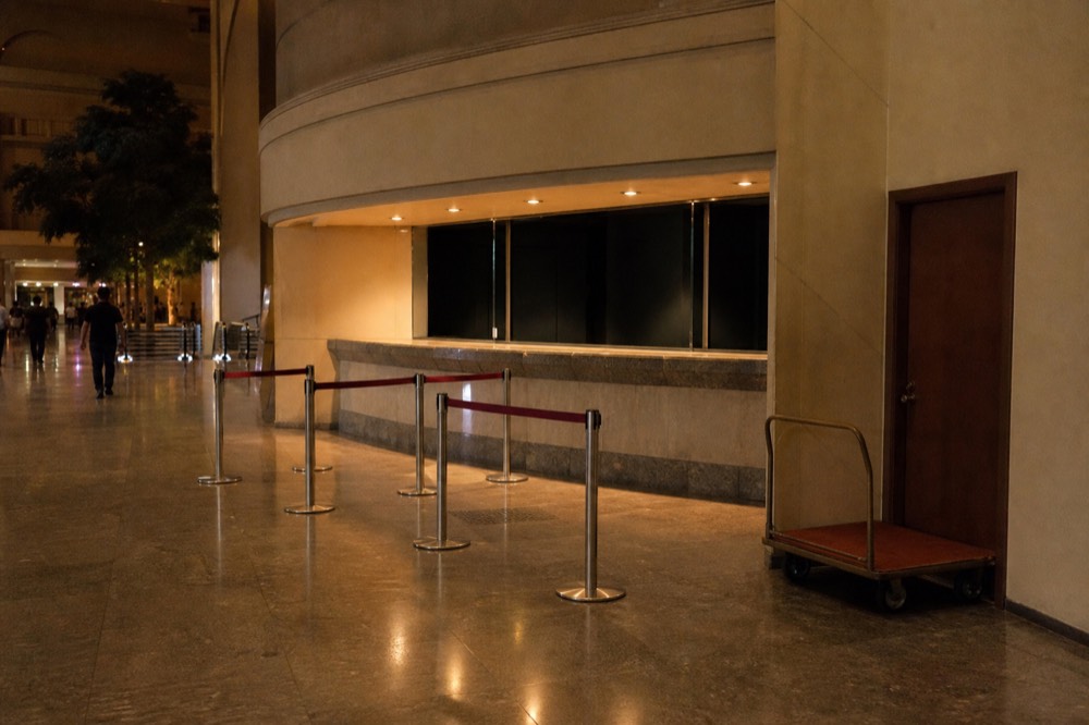 A theatre foyer ticket counter with an empty queue barrier before an evening performance